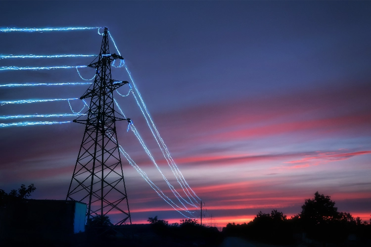 Electricity Transmission Towers With Glowing Wires Against Sunset Sky Background@2X
